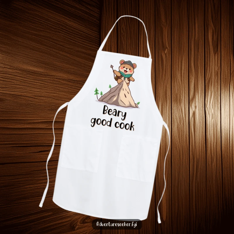 Funny apron showing a cute bear adventurer character joyfully climbing a mountain, designed for kitchen fun and protection.