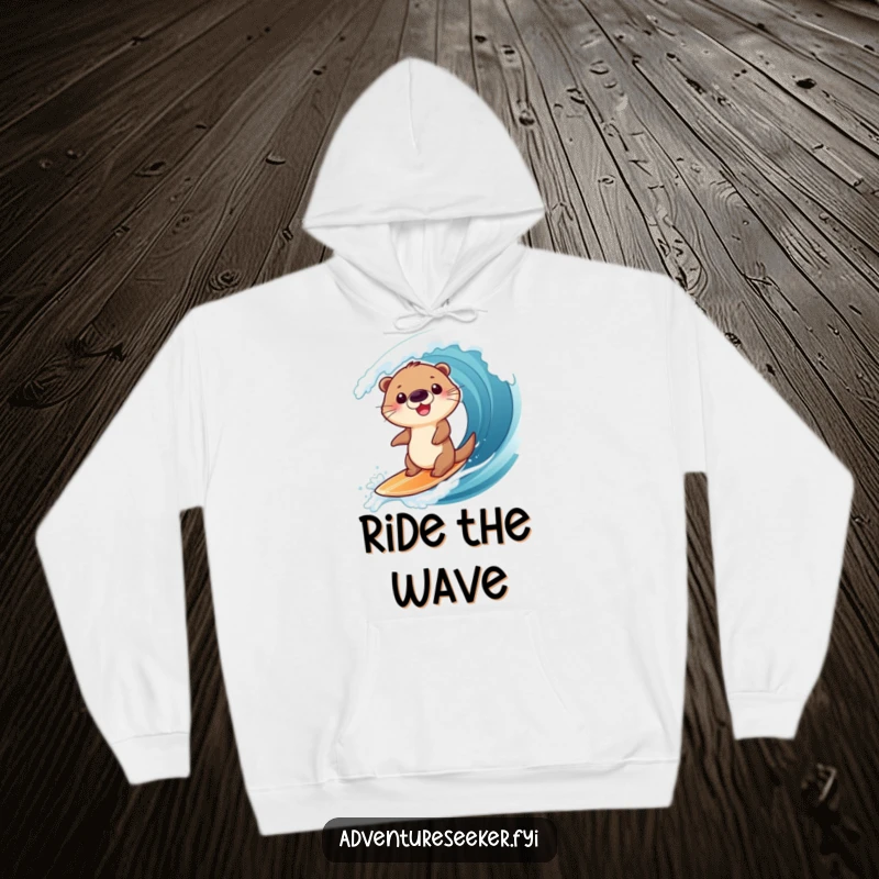 Funny hoodie featuring a happy otter character surfing a big wave, offering warmth and a dose of aquatic humor, a comfy gift.