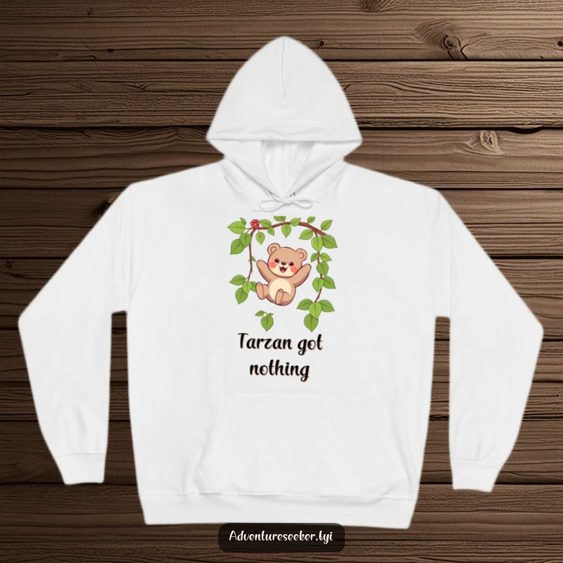 Funny hoodie depicting a small bear character joyfully swinging on a vine, radiating happiness and a love for adventure.