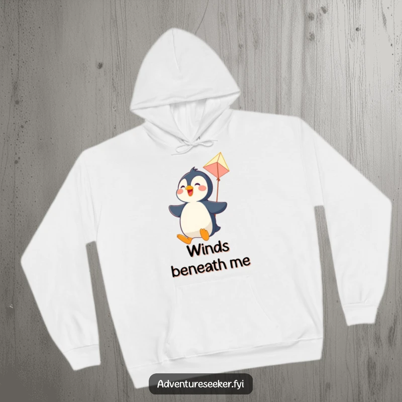 Funny hoodie showing a joyful penguin character soaring through the air on a makeshift kite, radiating pure happiness.